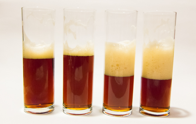 The 4 beers that were tasted. From left "no yeast/no O2", "no yeast/O2", "yeast/ no O2" "yeast/O2". The picture was taken during the foam stability test. The two samples on the right were poured 1 min after the samples on the left were poured. 